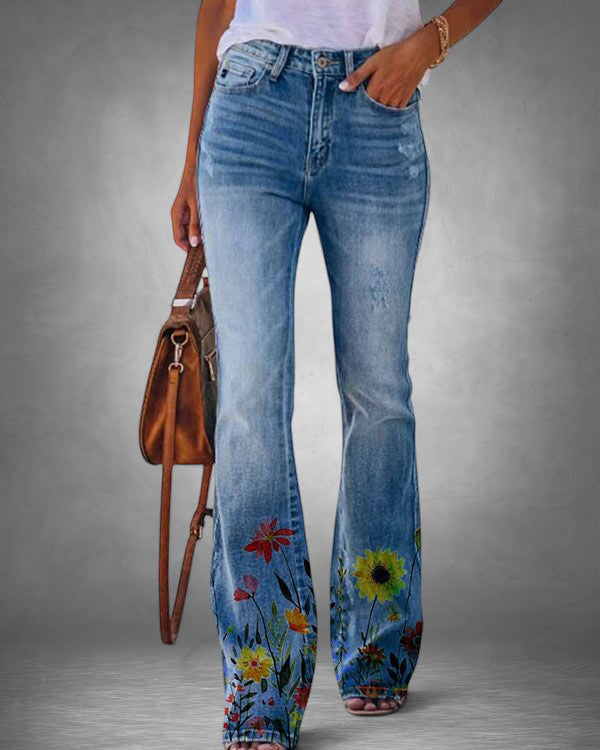 ZOFIA ATELIER light wash denim flare jeans with colorful floral print on the lower legs.