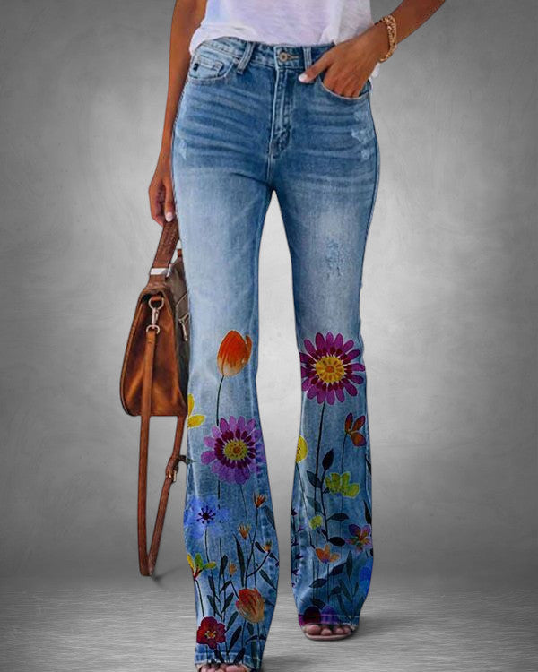 ZOFIA ATELIER blue denim flare jeans with vibrant floral print on legs. Distressed details.