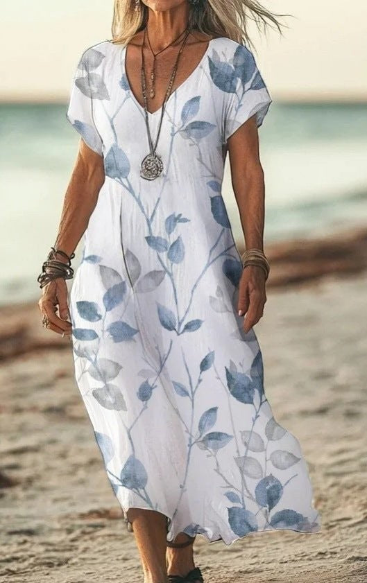 ZOFIA ATELIER white V-neck midi dress with blue floral print and short sleeves, flowing fabric.