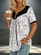 ZOFIA ATELIER white floral print v-neck short sleeve top with black contrast and button detail. Lightweight, flowy fabric.