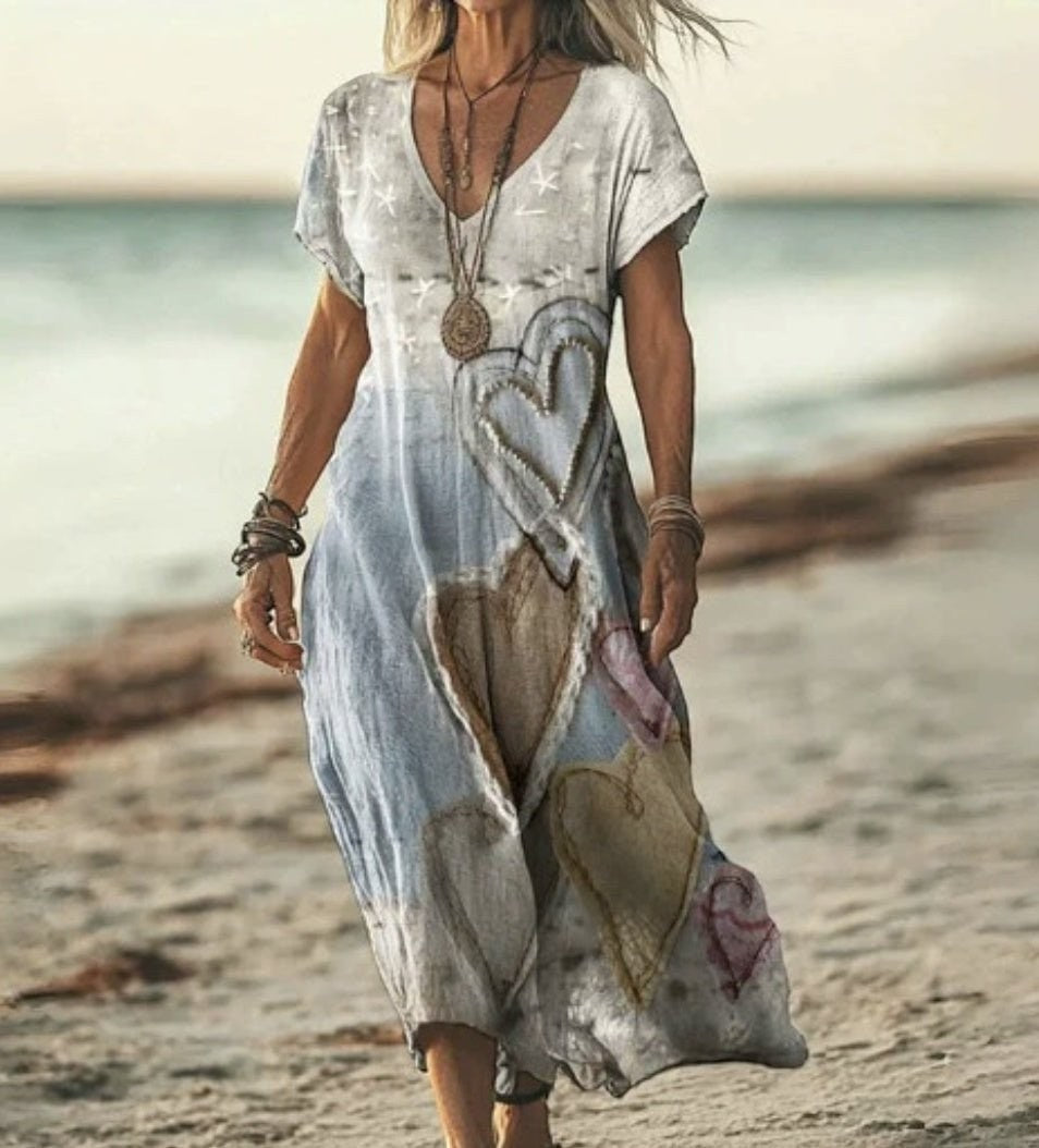 ZOFIA ATELIER Gabrysia floral V-neck midi dress with heart appliques, short sleeves, and flowing silhouette on a beach.