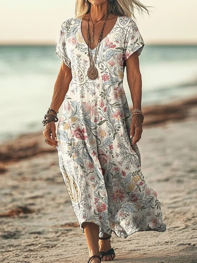 ZOFIA ATELIER Gabrysia floral V-neck midi dress with short sleeves and a flowing silhouette, worn on a beach.