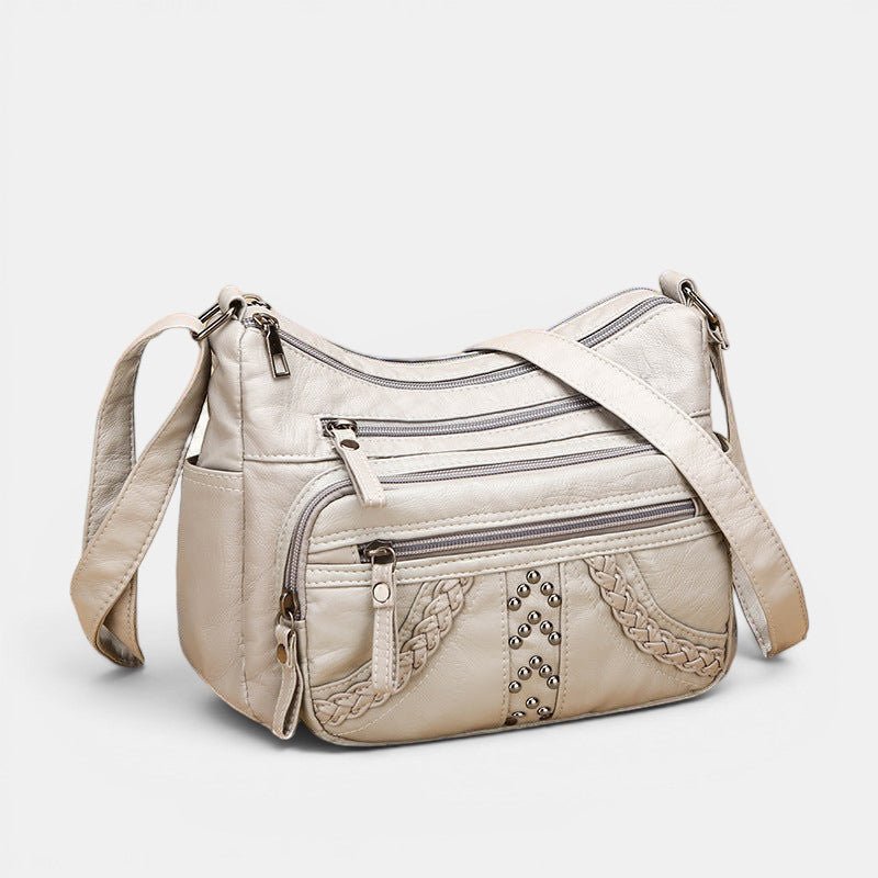 ZOFIA ATELIER GRAŻYNA multi-layer crossbody bag in light gray PU leather with braided accents and stud details.