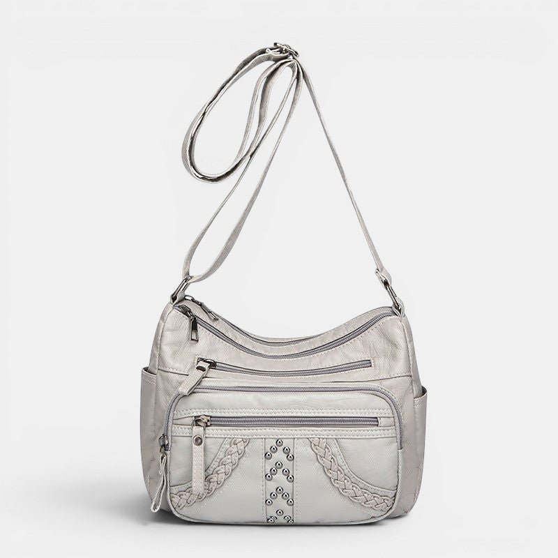 ZOFIA ATELIER light gray multi-layer PU crossbody bag with braided detail and silver studs.
