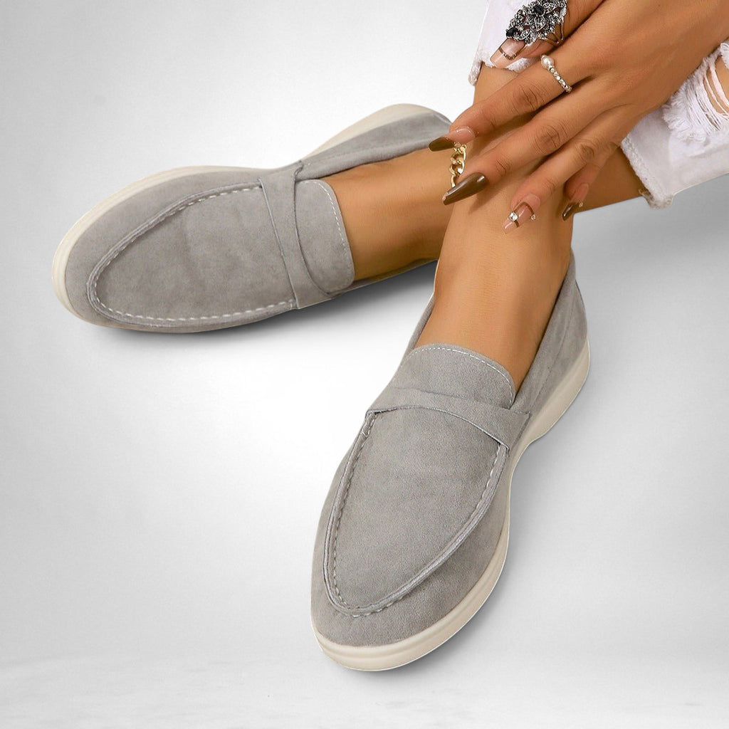 ZOFIA ATELIER grey suede-style slip-on flats with white stitching and a comfortable flat sole.