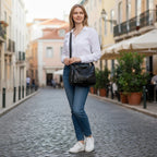 ZOFIA ATELIER Helena black PU leather crossbody bag with multiple pockets and silver hardware, worn by a woman in jeans and white shirt.