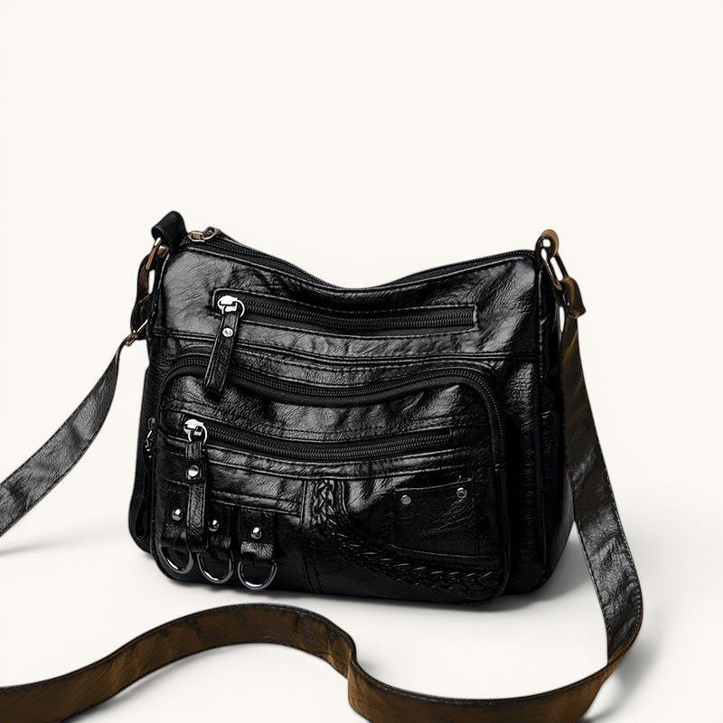 ZOFIA ATELIER Helena luxury crossbody bag in black PU leather with multiple zippered pockets and braided detail.