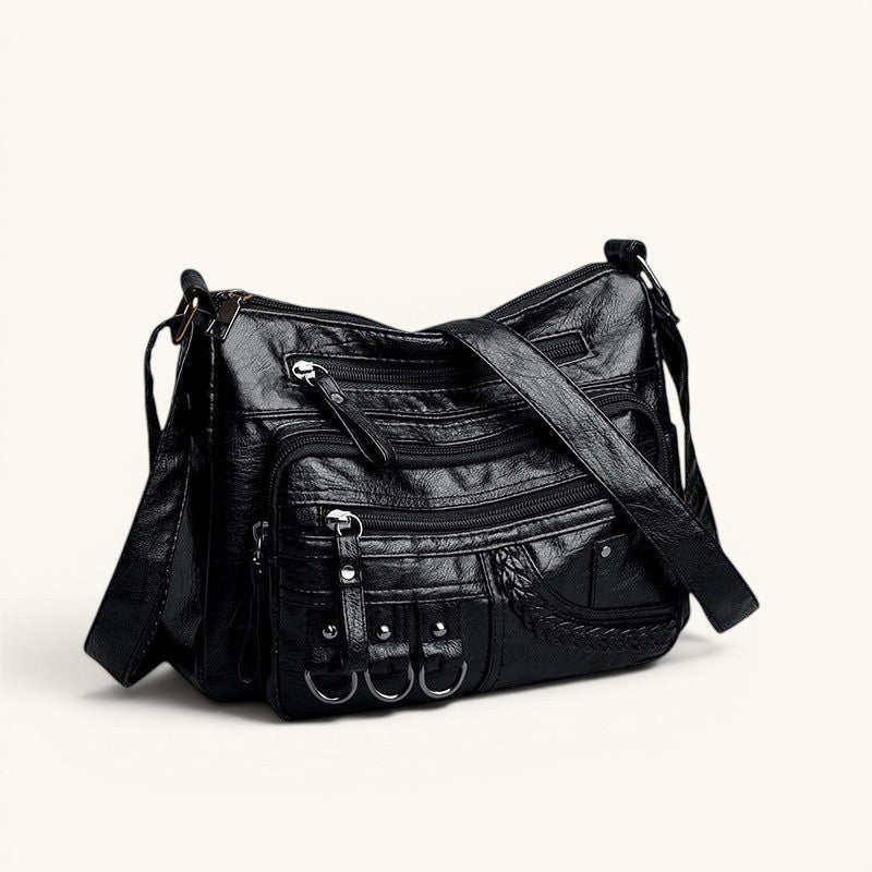 ZOFIA ATELIER HELENA luxury crossbody bag in black PU leather with multiple zippered pockets and braided detail.