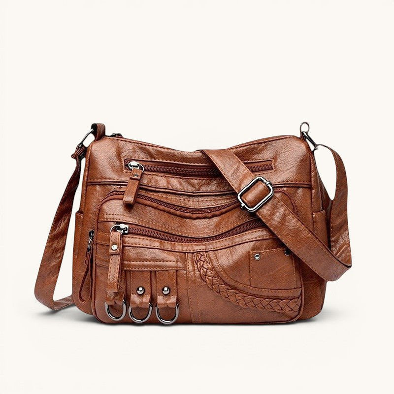 ZOFIA ATELIER Helena luxury crossbody bag in brown PU leather with multiple zippered pockets and braided detail.