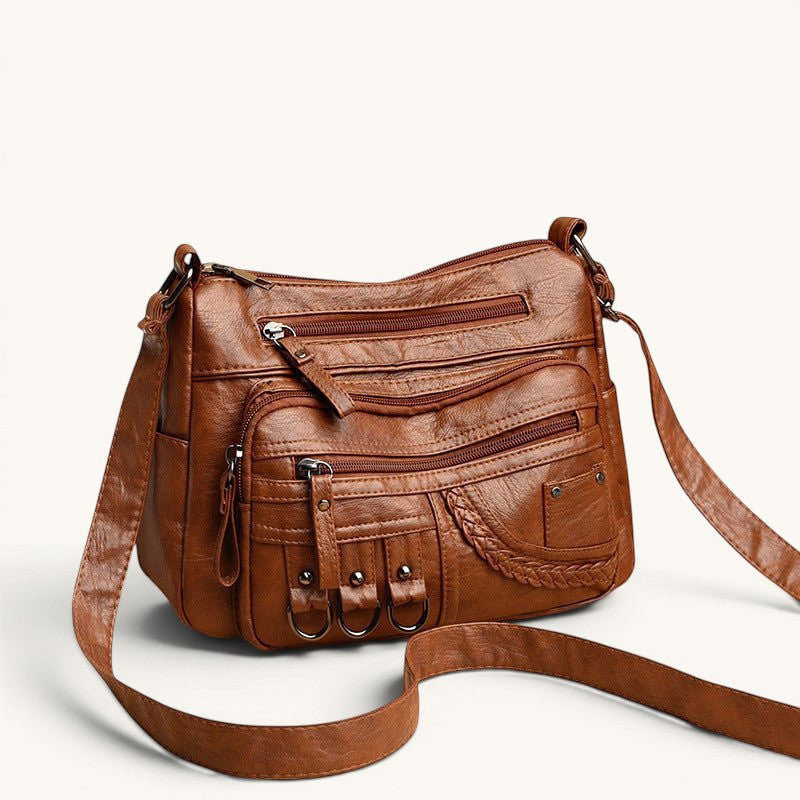 ZOFIA ATELIER Helena luxury crossbody bag in brown PU leather with multiple zippered pockets and braided detail.