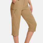 ZOFIA ATELIER Khaki PVC capri pants with asymmetric patchwork design and zippered cargo pocket.