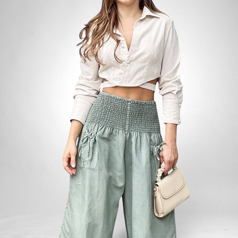 ZOFIA ATELIER beige long-sleeve cropped shirt with white buttons and light green high-waisted ruffled pants.