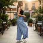 ZOFIA ATELIER light blue wide-leg pants with smocked high waist and ruffled hem, worn by a woman outdoors.