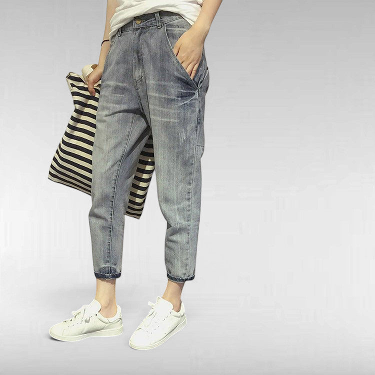 ZOFIA ATELIER light wash slim stretch cotton jeans with cuffed ankles, worn by a model holding a striped bag.