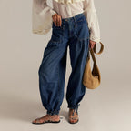 ZOFIA ATELIER loose mid-waist blue denim jeans with gathered ankles and front pockets. Model wears sandals and a white blouse.