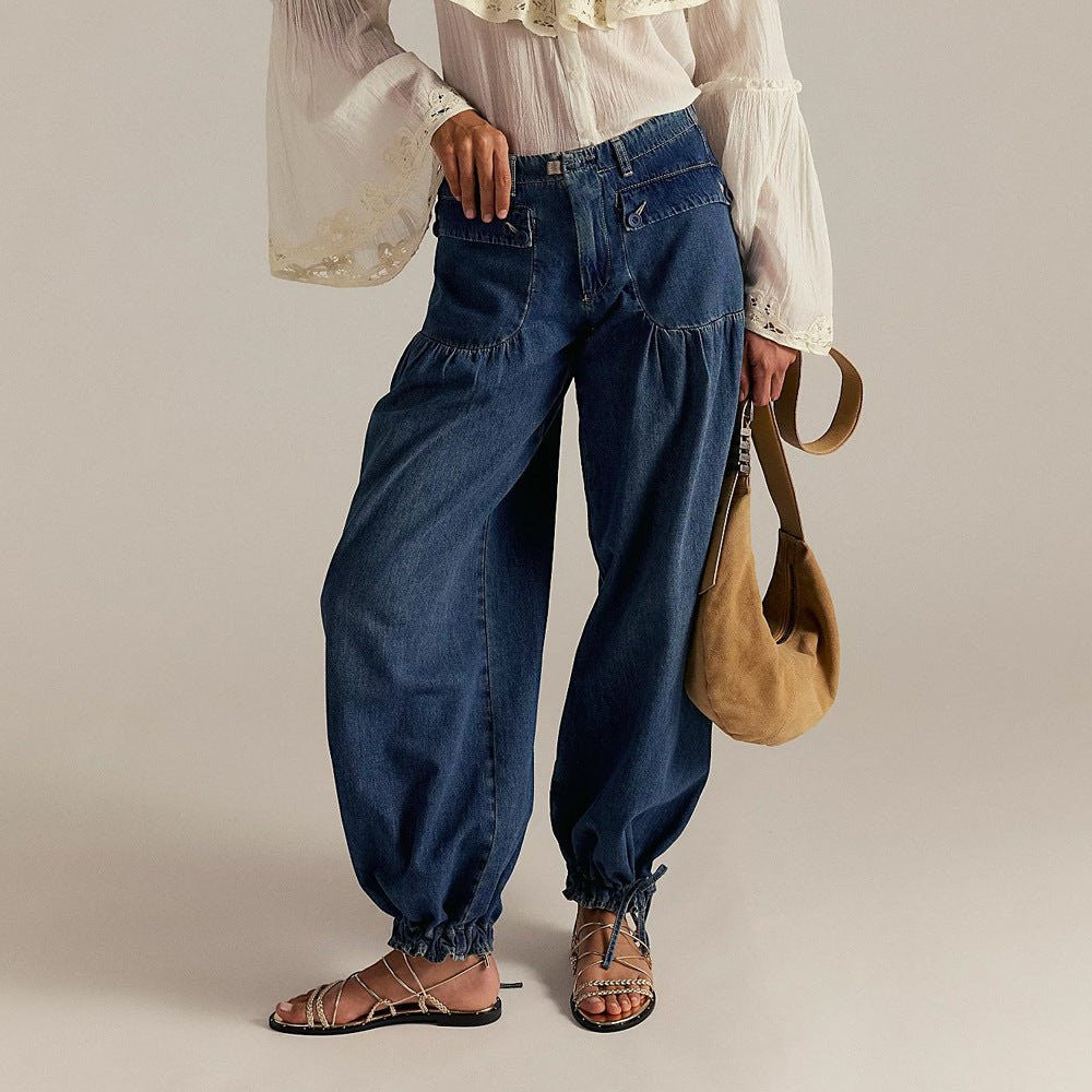 ZOFIA ATELIER loose mid-waist blue denim jeans with gathered ankles and front pockets. Model wears sandals and a white blouse.