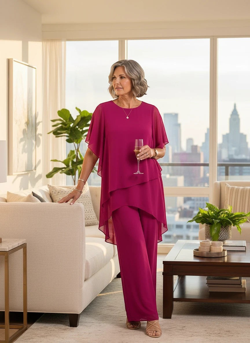 ZOFIA ATELIER MARINA chiffon suit set in rose red with quarter sleeves and trousers. Model holds champagne.