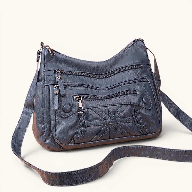 ZOFIA ATELIER AGNIESZKA dark grey PU leather messenger bag with multiple zippered pockets and braided detail.