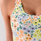 ZOFIA ATELIER Nadia backless sculpt swimsuit in white with a floral print of orange, yellow, and purple flowers.