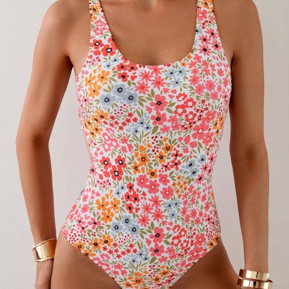ZOFIA ATELIER Nadia backless sculpt swimsuit in a white floral print with pink, orange, and blue flowers.
