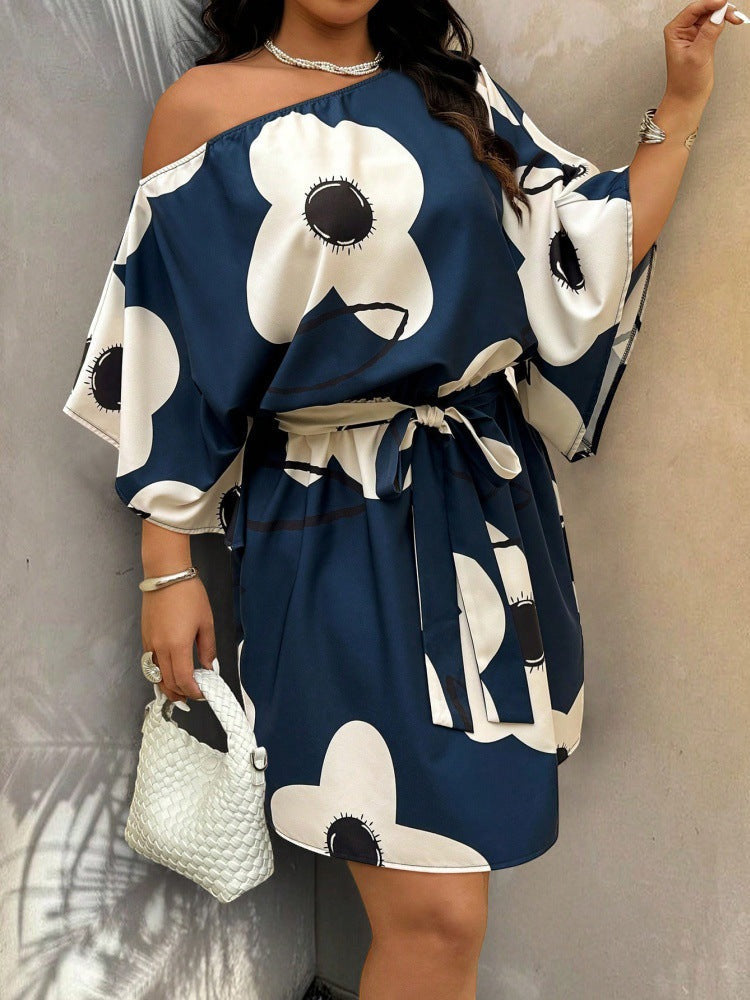 ZOFIA ATELIER navy blue and apricot off-shoulder mini dress with a bold white floral pattern and tie waist.