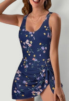 ZOFIA ATELIER navy blue one-piece swimsuit with a floral print and a tie-front skirt detail.