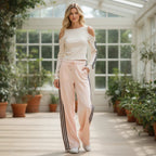 ZOFIA ATELIER off-shoulder long sleeve top and wide-leg track pants set in cream and pale pink with black stripes.