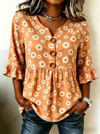 ZOFIA ATELIER orange short-sleeved polyester top with white daisy print, V-neck, button-up front, and ruffled sleeves.