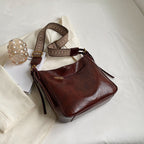 ZOFIA ATELIER PATRYCJA retro crossbody bag in dark brown PU leather with a patterned strap.