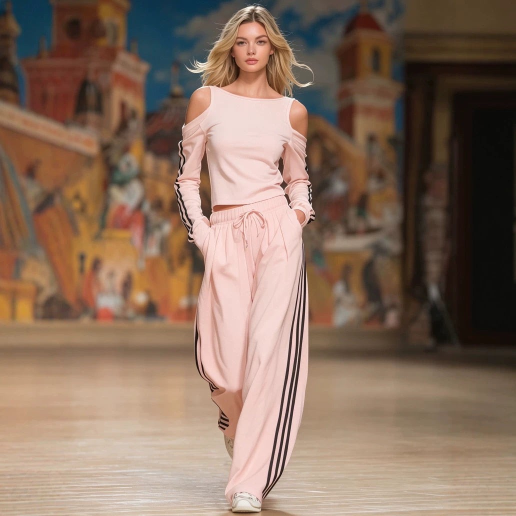 ZOFIA ATELIER pink off-shoulder long sleeve top and wide-leg pants set with black stripes on sleeves and pants.