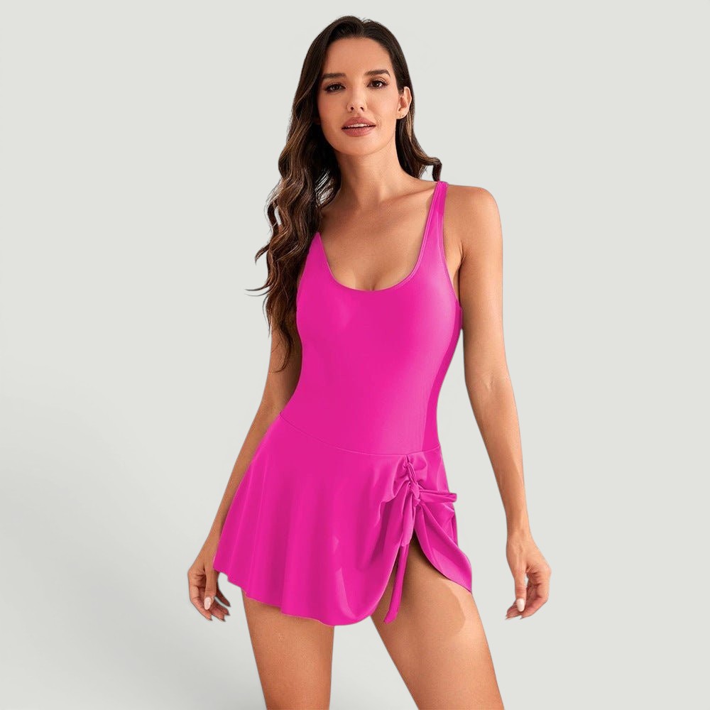ZOFIA ATELIER IZA digital art swimsuit in bright pink with a tie detail on the side skirt. Model is wearing a size M.