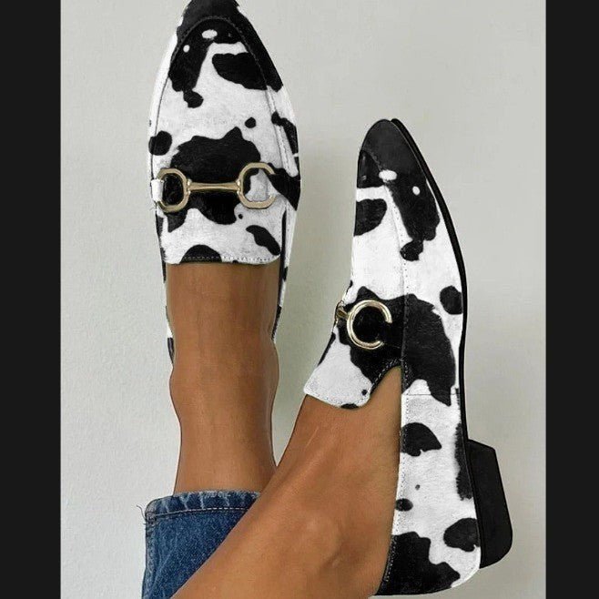 ZOFIA ATELIER Katarzyna pointed toe mules in black and white cow print with gold horsebit detail.