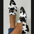 ZOFIA ATELIER Katarzyna pointed toe mules in black and white cow print with gold horsebit detail.