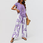 ZOFIA ATELIER purple top and white pants set with purple leaf print, three-quarter sleeves, full length wide-leg pants.