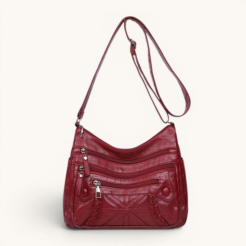 ZOFIA ATELIER Agnieszka red PU leather messenger bag with multiple zippered pockets and braided detail.