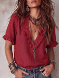 ZOFIA ATELIER red V-neck ruffled short-sleeve polyester shirt worn by a model with layered necklaces and bracelets.