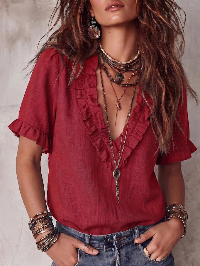 ZOFIA ATELIER red V-neck ruffled short-sleeve polyester shirt worn by a model with layered necklaces and bracelets.