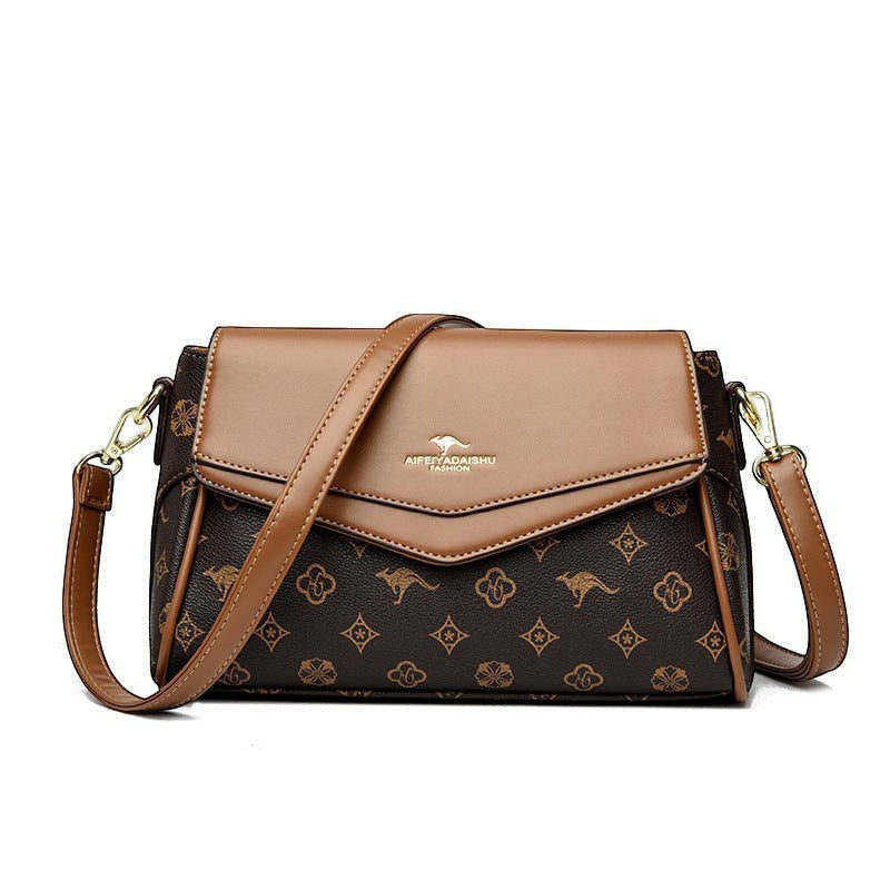 ZOFIA ATELIER Renata crossbody bag in brown PU with patchwork stitching and monogram print. Horizontal rectangular shape.