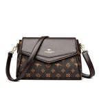 ZOFIA ATELIER Renata crossbody bag in brown PU with monogram print and patchwork stitching detail.