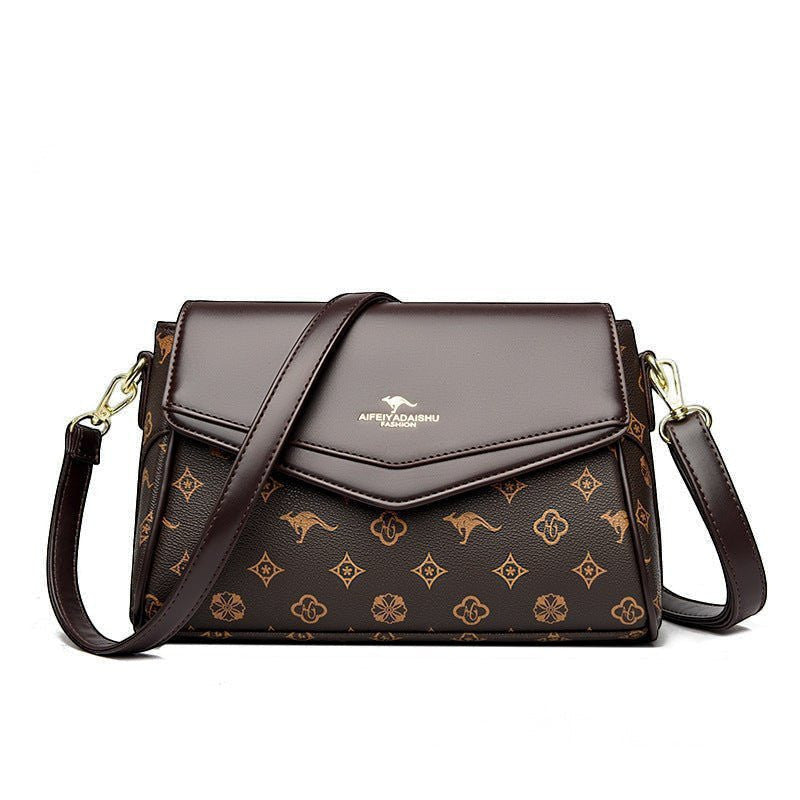 ZOFIA ATELIER Renata crossbody bag in brown PU with monogram print and patchwork stitching detail.