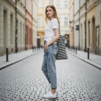 ZOFIA ATELIER light wash slim stretch cotton jeans worn by a model on a cobblestone street.