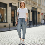 ZOFIA ATELIER light wash slim stretch jeans on a woman standing on a cobblestone street.