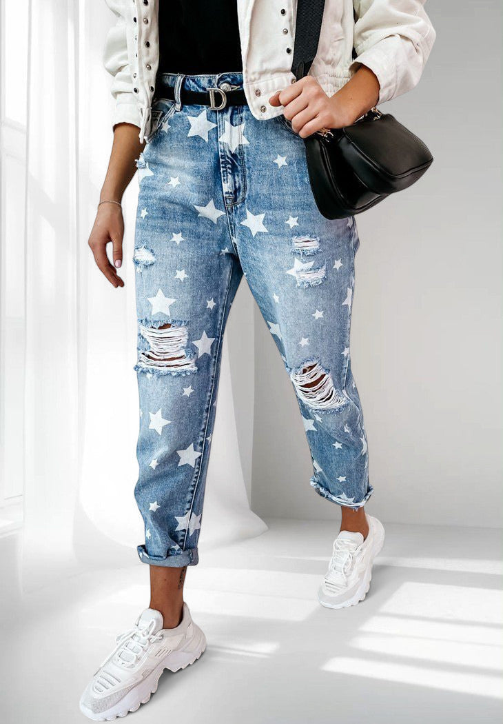 ZOFIA ATELIER blue denim trousers with white stars and distressed details, slim fit, straight leg, cuffed hems.