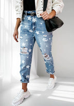 ZOFIA ATELIER blue denim trousers with white stars and distressed details, slim fit, straight leg, cuffed hems.