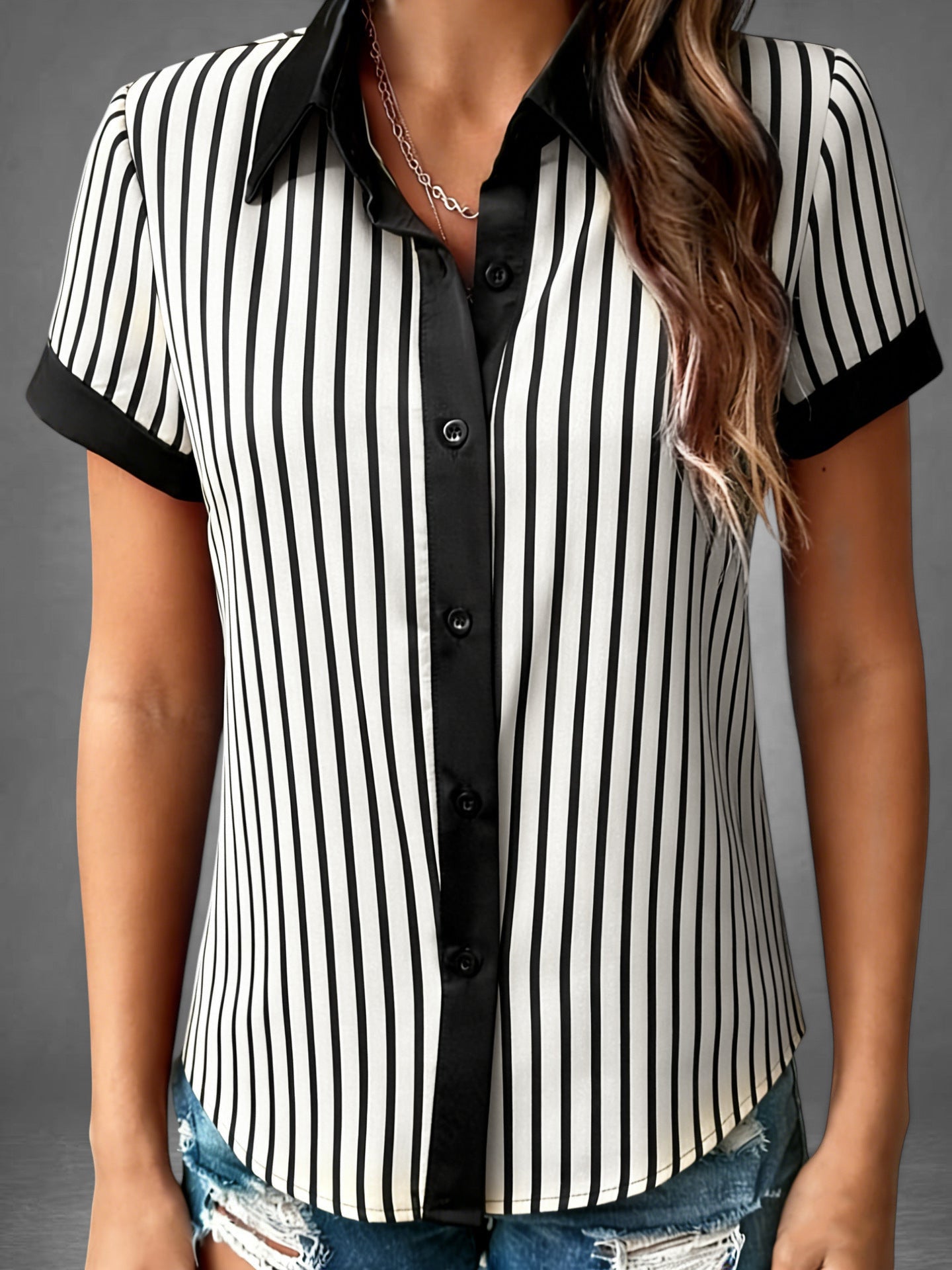 ZOFIA ATELIER loose short-sleeve blouse with black and white vertical stripes and black collar and cuffs.