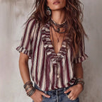 ZOFIA ATELIER striped V-neck ruffled polyester shirt with short sleeves. Model wears layered necklaces.