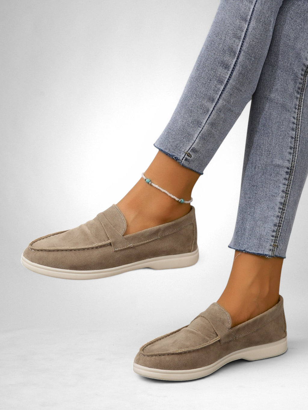 ZOFIA ATELIER taupe suede slip-on loafers with a retro design and flat sole, worn with blue jeans.