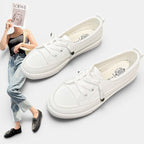 ZOFIA ATELIER white canvas sneakers with flat heel and round toe, front laces, and rubber outsole.