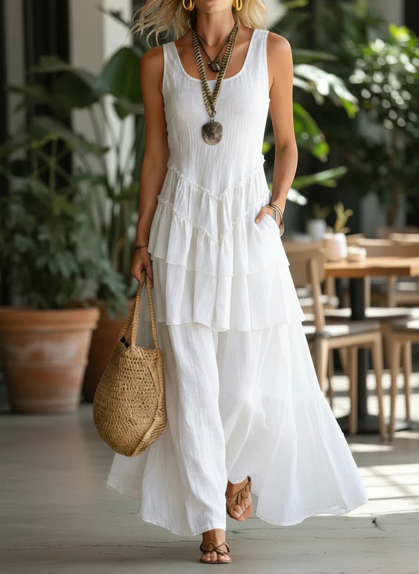 ZOFIA ATELIER white linen sleeveless tiered maxi dress with ruffled details and pockets.