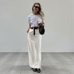 ZOFIA ATELIER white spandex A-line maxi skirt with high waist and back slit, styled casually.